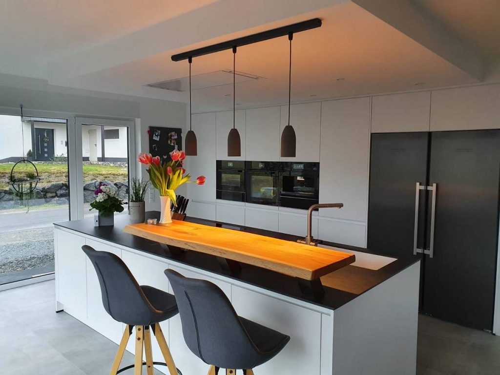 Küchentresen mit Betonlampe und schwarzer Deckenaufhängung